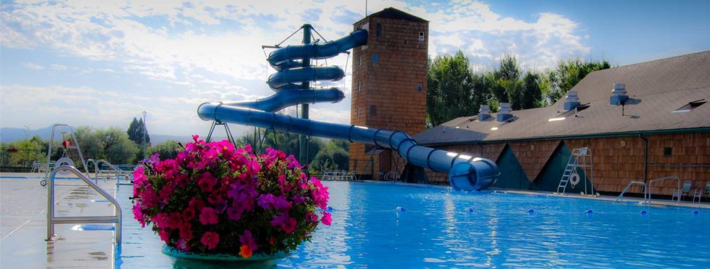outdoor pool at fairmont hot springs with water slide and flowers
