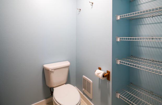 79 Starlight Drive - toilet to the left, wire shelving installed in alcove to the right. light blue painted walls.