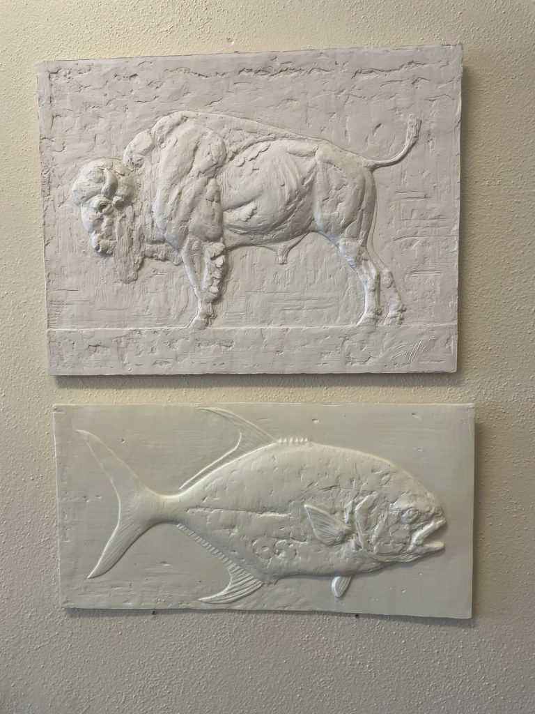 Artwork of a bison and another one of fish on the wall inside of the Emerson Center for the arts and culture