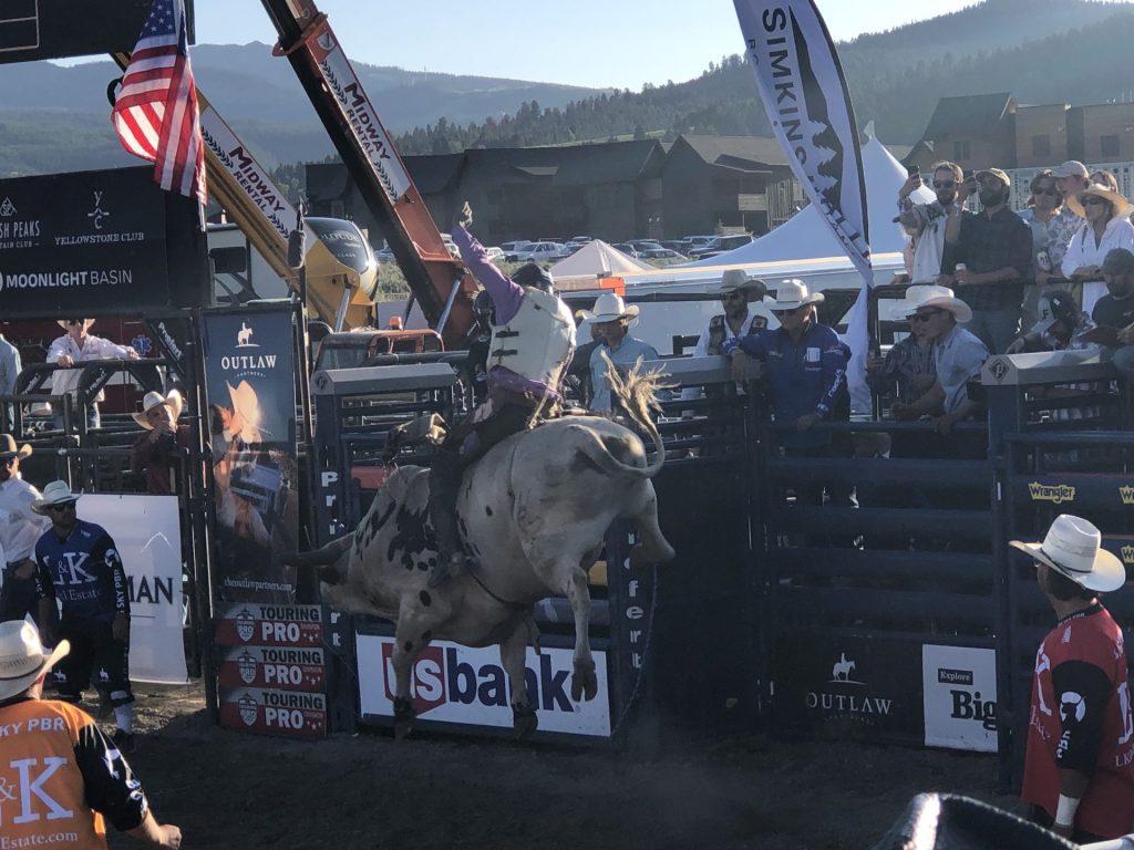 Cowboy riding bull at rodeo